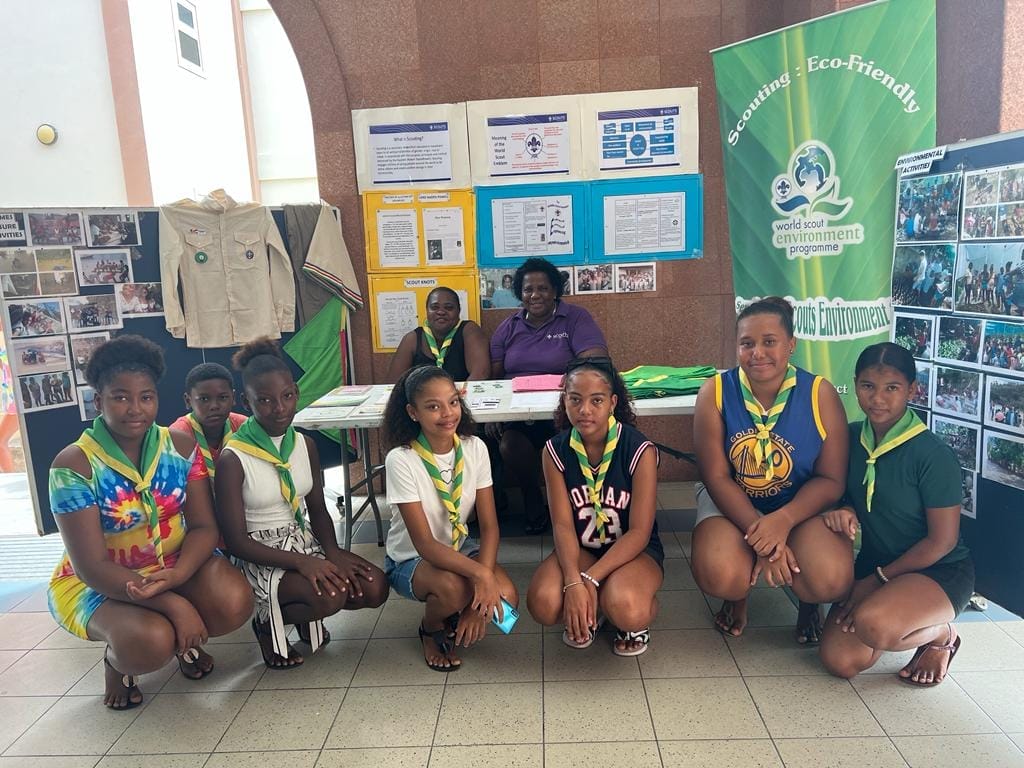 Young Seychelles Scouts and leaders at an informational booth promoting eco-friendly practices and environmental engagement as part of their scouting activities.